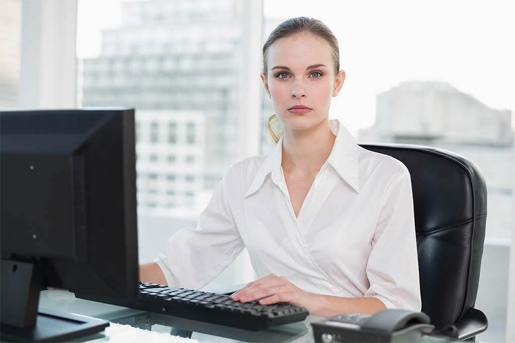 Sekretärin bearbeitet ein digitales Formular in einem Büro vor Fenster mit Aussicht